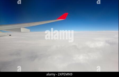 San Pablo, Brésil. 03 septembre 2010 : aile d'avion avec une pointe rouge volant au-dessus des nuages. Banque D'Images