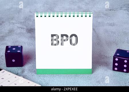 Concept commercial. Lettres BPO. Externalisation des processus métier sur un carnet de notes sur fond gris Banque D'Images