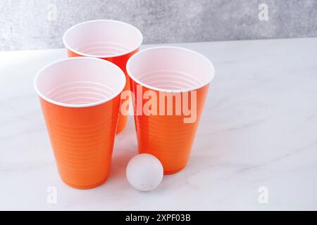 Une vue de quelques gobelets jetables et une balle de ping-pong, souvent associée au jeu de bière-pong. Banque D'Images