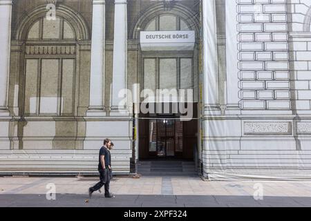 06 août 2024, Hesse, Francfort-sur-le-main : deux hommes passent devant l'échafaudage couvert devant la Bourse de Francfort. Photo : Helmut Fricke/dpa Banque D'Images