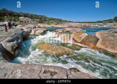 Jeunes garçons regardant les rapides au canal de Pedernales River, Pedernales Falls State Park, Hill Country, Texas, États-Unis Banque D'Images