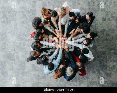 Vue de dessus de divers professionnels unis dans un caucus, symbolisant le travail d'équipe, la collaboration et l'unité dans un environnement d'entreprise. Banque D'Images