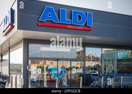 Torrevieja, Espagne - 09-07-2024 : extérieur d'un magasin ALDI. La devanture du magasin est visible avec des portes en verre transparent et une ligne de chariots, placés contre Banque D'Images