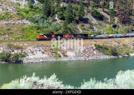 Train de marchandises avec locomotive sur voie ferrée près du fleuve Fraser des chemins de fer du canadien Pacifique, Colombie-Britannique, Canada. Banque D'Images