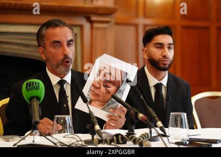Le Solictor Aamer Anwar, montre une photo de Shameem Akhtar, 56 ans, que son fils Fahir Amaaz, 19 ans, regarde lors d'une conférence de presse à l'hôtel Midland à Manchester, alors qu'ils ont parlé au FIPOL de "concernant le dépôt d'une plainte formelle contre des officiers". Des manifestations ont éclaté à Rochdale et dans le centre-ville de Manchester après la diffusion d'une vidéo montrant un policier qui aurait donné des coups de pied et des coups de poing à un homme alors qu'il était allongé le visage caché lors d'une arrestation à l'aéroport le 23 juillet. Date de la photo : mardi 6 août 2024. Banque D'Images