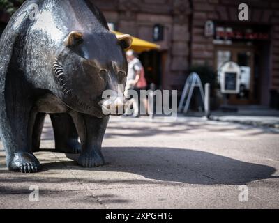 06 août 2024, Hesse, Francfort-sur-le-main : L'ours, symbole de la chute des cours boursiers, se dresse comme une sculpture en bronze avec le taureau sur une place devant le bâtiment de la Bourse de Francfort. Photo : Frank Rumpenhorst/dpa Banque D'Images