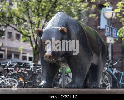 06 août 2024, Hesse, Francfort-sur-le-main : L'ours, symbole de la chute des cours boursiers, se dresse comme une sculpture en bronze avec le taureau sur une place devant le bâtiment de la Bourse de Francfort. Photo : Frank Rumpenhorst/dpa Banque D'Images