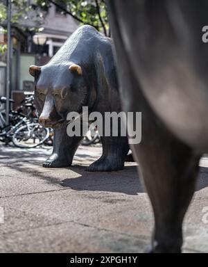 06 août 2024, Hesse, Francfort-sur-le-main : L'ours, symbole de la chute des cours boursiers, se dresse comme une sculpture en bronze avec le taureau sur une place devant le bâtiment de la Bourse de Francfort. Photo : Frank Rumpenhorst/dpa Banque D'Images