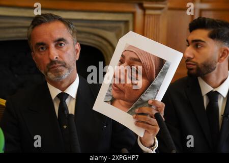L'avocat Aamer Anwar, montre une photo de Shameem Akhtar, 56 ans, alors que son fils Fahir Amaaz, 19 ans, regarde lors d'une conférence de presse à l'hôtel Midland à Manchester, alors qu'ils ont parlé au FIPOL au sujet de «la plainte formelle contre des officiers». Des manifestations ont éclaté à Rochdale et dans le centre-ville de Manchester après la diffusion d'une vidéo montrant un policier qui aurait donné des coups de pied et des coups de poing à un homme alors qu'il était allongé le visage caché lors d'une arrestation à l'aéroport le 23 juillet. Date de la photo : mardi 6 août 2024. Banque D'Images