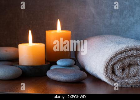 Spa Still Life avec bougies allumées, serviettes et galets Banque D'Images