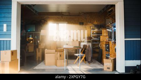 Prise de vue du bureau vide du propriétaire d'une petite entreprise dans le garage rétro. Boîtes en carton avec des produits emballés pour l'expédition aux clients couchant autour. Concept d'entreprise familiale et d'entrepreneuriat. Banque D'Images