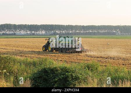 un tracteur avec un gros injecteur fertilise des terres agricoles dans la campagne néerlandaise en été Banque D'Images