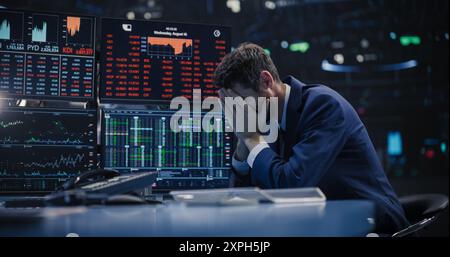 Stressé Stock Exchange Trader ne peut pas appréhender un effondrement soudain du marché boursier. Concept de crise financière avec Stock Broker attristé par des informations de téléscripteur négatives, des graphiques rouges et des données en temps réel Banque D'Images