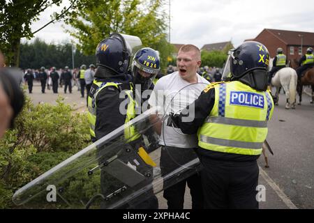 Photo du dossier datée du 04/08/24 des policiers qui détiennent un homme maintenant identifié comme Liam Grey, 20 ans, de Randerson Drive, Kilnhurst, Mexborough, South Yorkshire, lors d'une manifestation anti-immigration devant le Holiday Inn Express à Rotherham, South Yorkshire. Grey s'est vu refuser aujourd'hui la libération sous caution au tribunal de première instance de Sheffield après avoir nié le désordre violent lié aux émeutes devant l'hôtel, après qu'il a été allégué qu'il a essayé de prendre un bouclier anti-émeute à un officier alors qu'il poussait contre la ligne de police. Date d'émission : mardi 6 août 2024. Banque D'Images