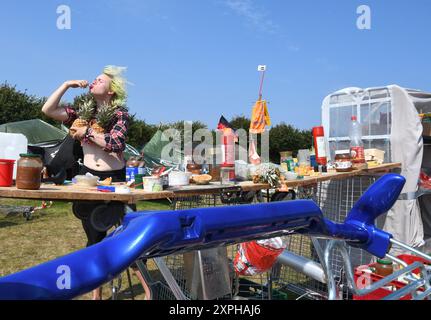 Tinnum, Sylt, Allemagne. 06 août 2024. Jonas Hötger (24 ans), co-organisateur du camp de protestation de Francfort, se tient dans la « cuisine » du camp de protestation punk sur le Festwiese. Jusqu'au 1er septembre, les participants au camp du groupe 'Aktion Sylt' veulent manifester sur l'île pour la solidarité, la justice climatique et contre la gentrification, entre autres choses. Crédit : Lea Albert/dpa/Alamy Live News Banque D'Images