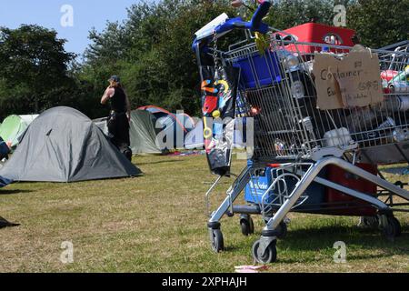 Tinnum, Sylt, Allemagne. 06 août 2024. Un participant au camp de protestation punk traverse le pré du camp derrière un chariot et entre des tentes. Jusqu'au 1er septembre, les participants au camp du groupe 'Aktion Sylt' veulent manifester sur l'île pour la solidarité, la justice climatique et contre la gentrification, entre autres. Crédit : Lea Albert/dpa/Alamy Live News Banque D'Images