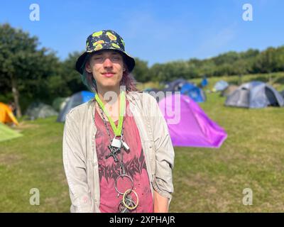 Tinnum, Sylt, Allemagne. 06 août 2024. Un punk surnommé Pissrinne se tient devant des tentes au camp de protestation punk sur le Festwiese. Jusqu'au 1er septembre, les participants au camp du groupe 'Aktion Sylt' veulent manifester sur l'île pour la solidarité, la justice climatique et contre la gentrification, entre autres choses. Crédit : Lea Albert/dpa/Alamy Live News Banque D'Images