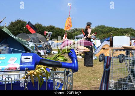 Tinnum, Sylt, Allemagne. 06 août 2024. Un participant au camp de protestation punk se tient derrière un chariot dans la prairie du camp. Jusqu'au 1er septembre, les participants au camp du groupe 'Aktion Sylt' veulent manifester sur l'île pour la solidarité, la justice climatique et contre la gentrification, entre autres choses. Crédit : Lea Albert/dpa/Alamy Live News Banque D'Images