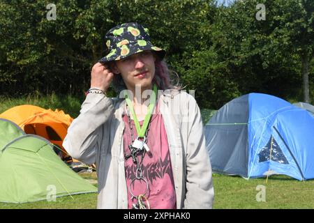 Tinnum, Sylt, Allemagne. 06 août 2024. Un punk surnommé Pissrinne se tient devant des tentes au camp de protestation punk sur le Festwiese. Jusqu'au 1er septembre, les participants au camp du groupe 'Aktion Sylt' veulent manifester sur l'île pour la solidarité, la justice climatique et contre la gentrification, entre autres choses. Crédit : Lea Albert/dpa/Alamy Live News Banque D'Images