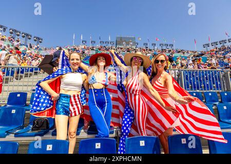 Femme américaine patriotique sautant et acclamant pour Team USA et les Jeux Olympiques de Paris 2024 devant la Tour Eiffel, Paris, France, Europe Banque D'Images