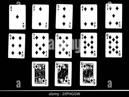 Un costume complet de diamants jouant des cartes en noir sur un fond noir. Banque D'Images