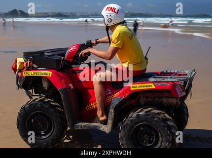 RNLI en service sur Watergate Bay, gardant une surveillance attentive pour tout accident et prêt pour des sauvetages rapides. Soyez fiers de ces bénévoles qualifiés pour leur travail Banque D'Images