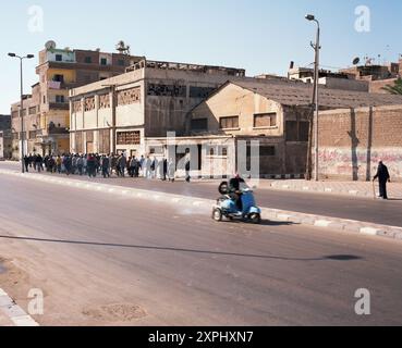 Un cortège funéraire solennel a lieu le long du canal Mahmoudiya à Alexandrie, en Égypte, en novembre 2006. La toile de fond urbaine et les personnes en deuil rassemblées soulignent les coutumes traditionnelles de la ville et le soutien communautaire. Banque D'Images