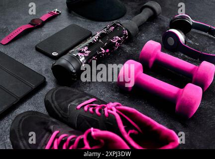 Fitness, sol et chaussures avec équipement d'exercice pour l'entraînement, technologie et bouteille d'eau dans le studio. Yoga, haltères et haltères d'entraînement avec Banque D'Images
