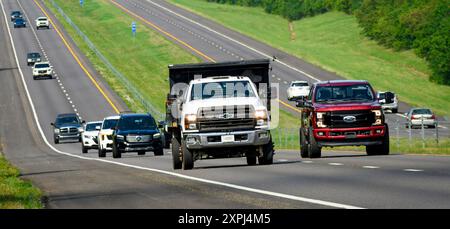 Maryville, Tennessee, États-Unis – 30 juin 2024 : photo horizontale d'une Chevrolet blanche et d'un camion Ford rouge côte à côte sur une autoroute inter-états. Banque D'Images