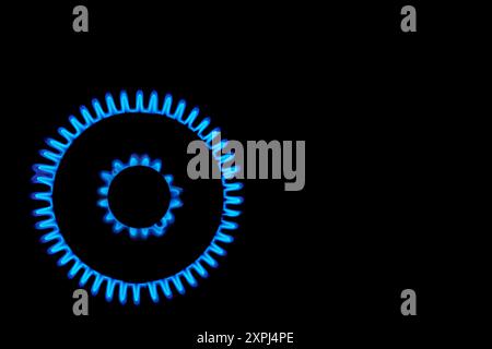 Gaz brûle bleu sur fond noir. Chauffage et Mirage au-dessus de la table de cuisson à gaz allumés. Vue de dessus d'un brûleur de cuisine allumant la nuit, gros plan. GA naturel Banque D'Images