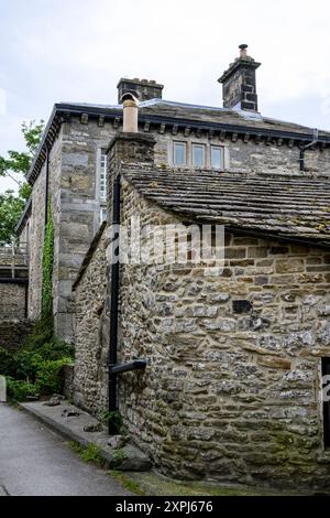 Grassington Yorkshire UK- 27 juillet 2024. Maison de campagne en pierre avec cheminée et verdure luxuriante dans un cadre paisible. Banque D'Images