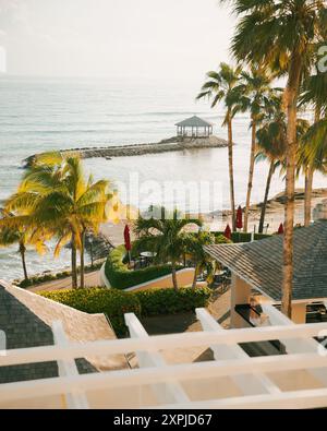 La magnifique Montego Bay, Jamaïque, mer des Caraïbes au coucher du soleil avec des palmiers et une jetée Banque D'Images