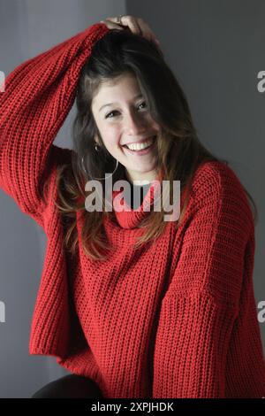 portrait de jeune fille joyeuse avec un pull rouge sur le fond Banque D'Images