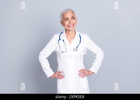 Photo de charmant médecin senior qualifié femme chirurgien pédiatre mains espace vide taille isolé sur fond de couleur grise Banque D'Images