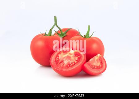 Tomate fraîche avec moitié et quart de tomate isolée sur fond blanc. Banque D'Images