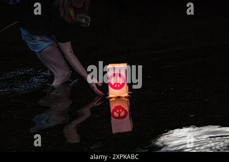 Salisbury, Wiltshire, Royaume-Uni, 6 août 2024. Campagne pour le désarmement nucléaire chandelles flottant reflétant la coutume japonaise des lanternes flottantes à la mémoire des morts. En souvenir de plus de 340 000 personnes qui sont mortes à la suite des bombes atomiques larguées sur Hiroshima et Nagasaki en août 1945, ainsi que de celles qui ont péri à la suite de tout le cycle nucléaire. Le flotteur de bougie comprenait des lanternes décorées par des enfants du lycée Kyoso à Hiroshima, au Japon, dans le cadre d'un engagement conjoint avec la CND pour débarrasser le monde des armes nucléaires. Crédit John Rose/Alamy Live News Banque D'Images