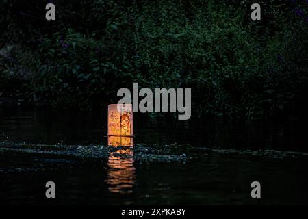 Salisbury, Wiltshire, Royaume-Uni, 6 août 2024. Campagne pour le désarmement nucléaire chandelles flottant reflétant la coutume japonaise des lanternes flottantes à la mémoire des morts. En souvenir de plus de 340 000 personnes qui sont mortes à la suite des bombes atomiques larguées sur Hiroshima et Nagasaki en août 1945, ainsi que de celles qui ont péri à la suite de tout le cycle nucléaire. Le flotteur de bougie comprenait des lanternes décorées par des enfants du lycée Kyoso à Hiroshima, au Japon, dans le cadre d'un engagement conjoint avec la CND pour débarrasser le monde des armes nucléaires. Crédit John Rose/Alamy Live News Banque D'Images