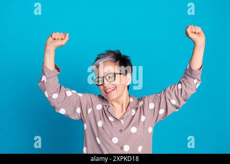 Photo de charmante femme retraitée joyeuse porter des vêtements de nuit élégants se réveiller isolé sur fond de couleur bleue Banque D'Images