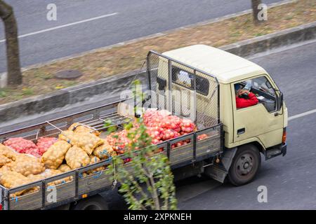 Un vieux camion transporte des sacs de pommes de terre et d'oignons par une journée ensoleillée Banque D'Images