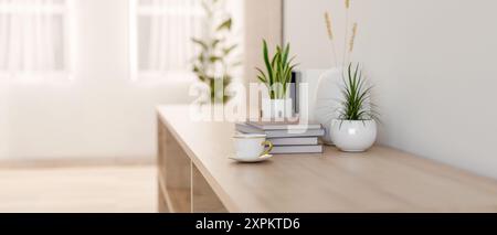 Une image de vue latérale en gros plan d'un buffet ou d'une armoire de couloir en bois avec une tasse à café, des livres et des plantes décoratives sur le dessus, dans un i minimal lumineux Banque D'Images