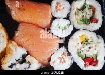 Dégustez un délicieux plateau de sushi assorti composé de saumon frais et de délicieux petits pains végétariens Banque D'Images