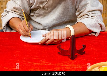 Gros plan photo de l'écriture de main humaine par pinceau de calligraphie stylo Banque D'Images