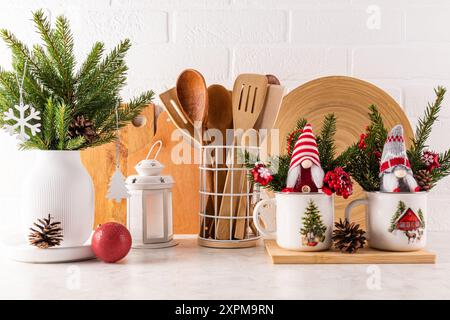 Un beau fond de cuisine décoré pour Noël. Ustensiles de cuisine respectueux de l'environnement, branches vertes d'une épicéa, gnomes du nouvel an Banque D'Images