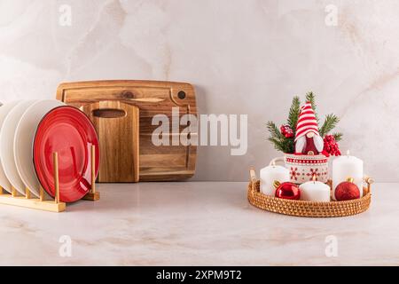 Comptoir de cuisine en marbre décoré dans un style minimaliste pour le nouvel an et Noël. Un séchoir avec des assiettes, un ensemble de bougies, un gnome du nouvel an Banque D'Images