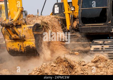 Gros plan godet de la pelle rétro creusant le sol sur le chantier de construction. Excavatrice sur chenilles creusant sur un site de démolition. Excavatrice. EQUIPEMENT de terrassement Banque D'Images