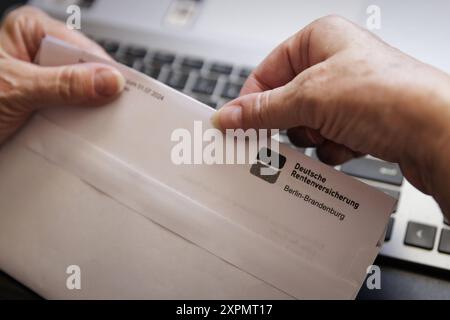 Eine aeltere Frau oeffnet einen Brief der Deutschen Rentenversicherung. Berlin, 05.08.2024. Berlin Deutschland *** une femme âgée ouvre une lettre de Deutsche Rentenversicherung Berlin, 05 08 2024 Berlin Allemagne Copyright : xKiraxHofmann/photothek.dex Banque D'Images