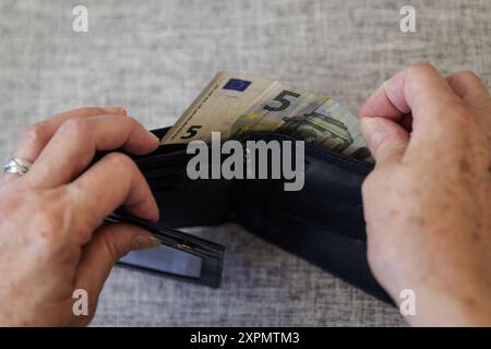 Eine aeltere Frau nimmt fuenf Euro aus ihrem Portemonnaie. Berlin, 05.08.2024. Berlin Deutschland *** une femme âgée tire cinq euros de son sac Berlin, 05 08 2024 Berlin Allemagne Copyright : xKiraxHofmann/photothek.dex Banque D'Images