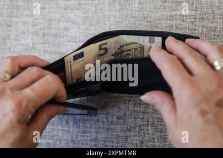 Eine aeltere Frau nimmt fuenf Euro aus ihrem Portemonnaie. Berlin, 05.08.2024. Berlin Deutschland *** une femme âgée tire cinq euros de son sac Berlin, 05 08 2024 Berlin Allemagne Copyright : xKiraxHofmann/photothek.dex Banque D'Images
