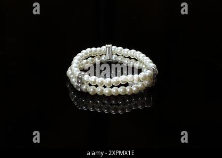 Bracelet perle double rangée sur verre noir, gros plan photo Banque D'Images