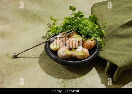 Escargogne Escargot de Bourgogne avec beurre, persil et épices sur fond vert Banque D'Images